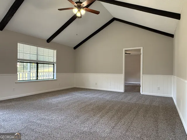 a view of a room with wooden floor chandeliers and kitchen view