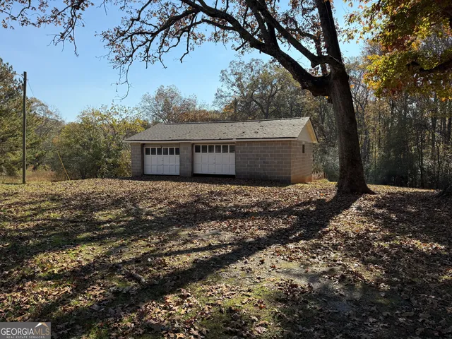 a front view of house with yard and trees in the background