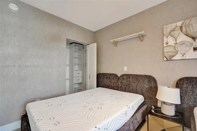 a bedroom with a bed and a large window