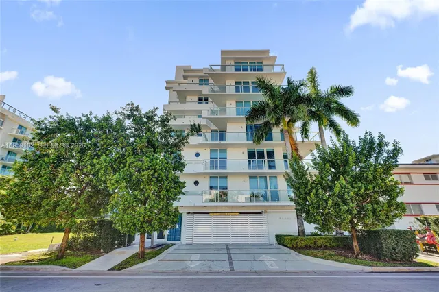 a tall building with large trees and windows