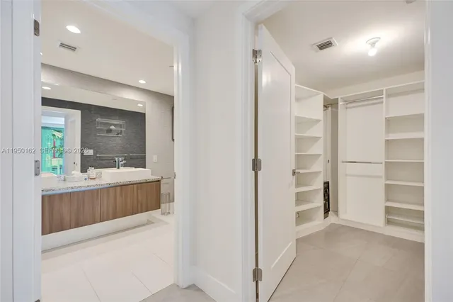 a spacious bedroom with a large bed and a chandelier