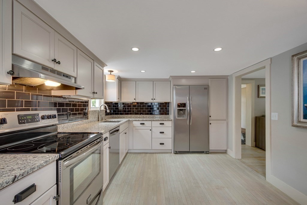16 Milford Avenue Natick, MA 01760 - Photo 16 of 34 a kitchen with white cabinets and stainless steel appliances