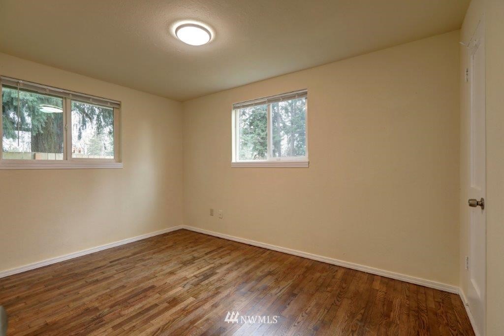 8818 Custer Road Southwest Lakewood, WA 98499 - Photo 3 of 10 an empty room with wooden floor and windows