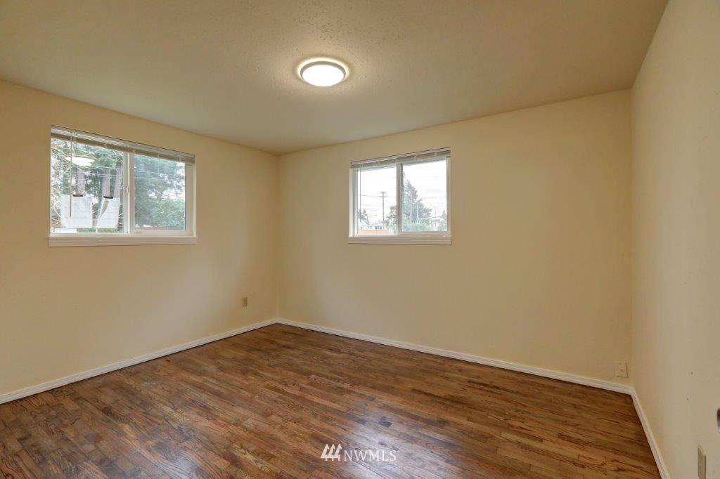 8818 Custer Road Southwest Lakewood, WA 98499 - Photo 4 of 10 an empty room with wooden floor and windows