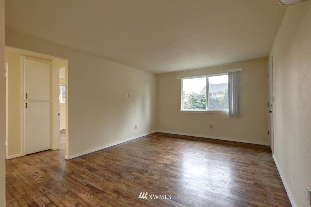 8818 Custer Road Southwest Lakewood, WA 98499 - Photo 8 of 10 an empty room with wooden floor cabinet and windows