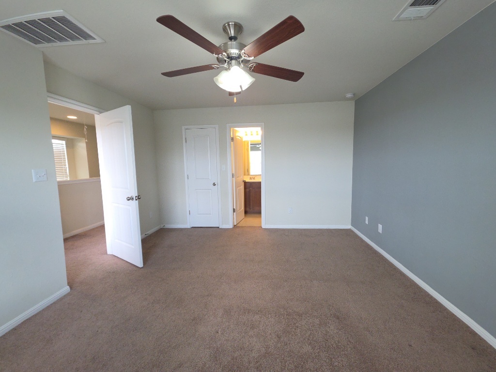 18009 Malnati Drive Pflugerville, TX 78660 - Photo 11 of 22 an empty room with a ceiling fan and a window