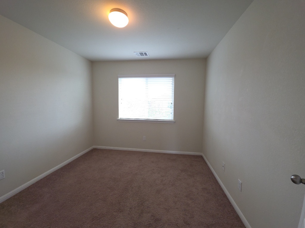18009 Malnati Drive Pflugerville, TX 78660 - Photo 14 of 22 an empty room with a window and a fan