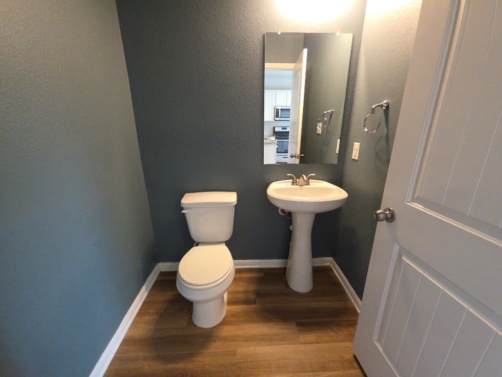 18009 Malnati Drive Pflugerville, TX 78660 - Photo 8 of 22 a bathroom with a toilet sink and a mirror