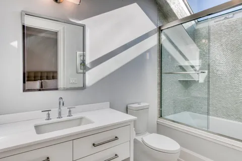 a bathroom with a sink a toilet and shower