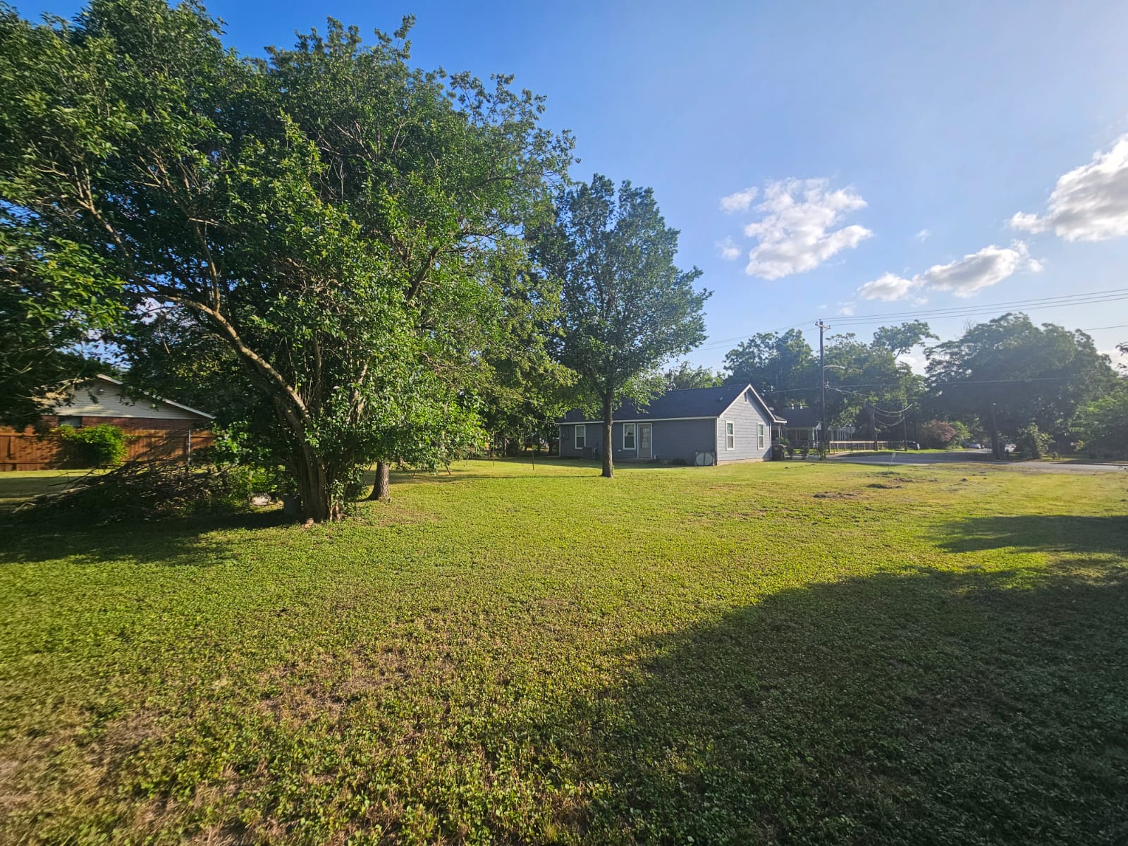 606 Trinity Street Lockhart, TX 78644 - Photo 23 of 23 A quaint residential structure is nestled amidst a spacious, well-maintained lawn.