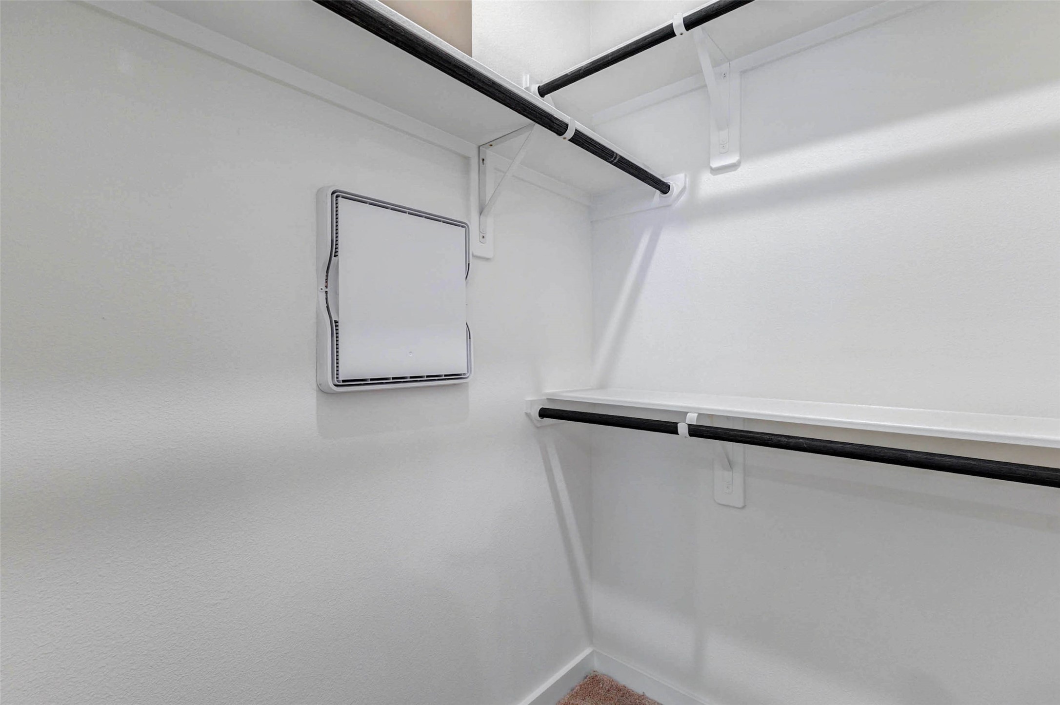 6475 Escondido Drive Rosharon, TX 77583 - Photo 21 of 32 The walk-in closet offers built-in shelving and hanging rods to help keep clothing, shoes, and everyday essentials organized. The clean white walls, upper storage space, and practical layout provide plenty of room to customize the closet for daily convenience and storage needs.