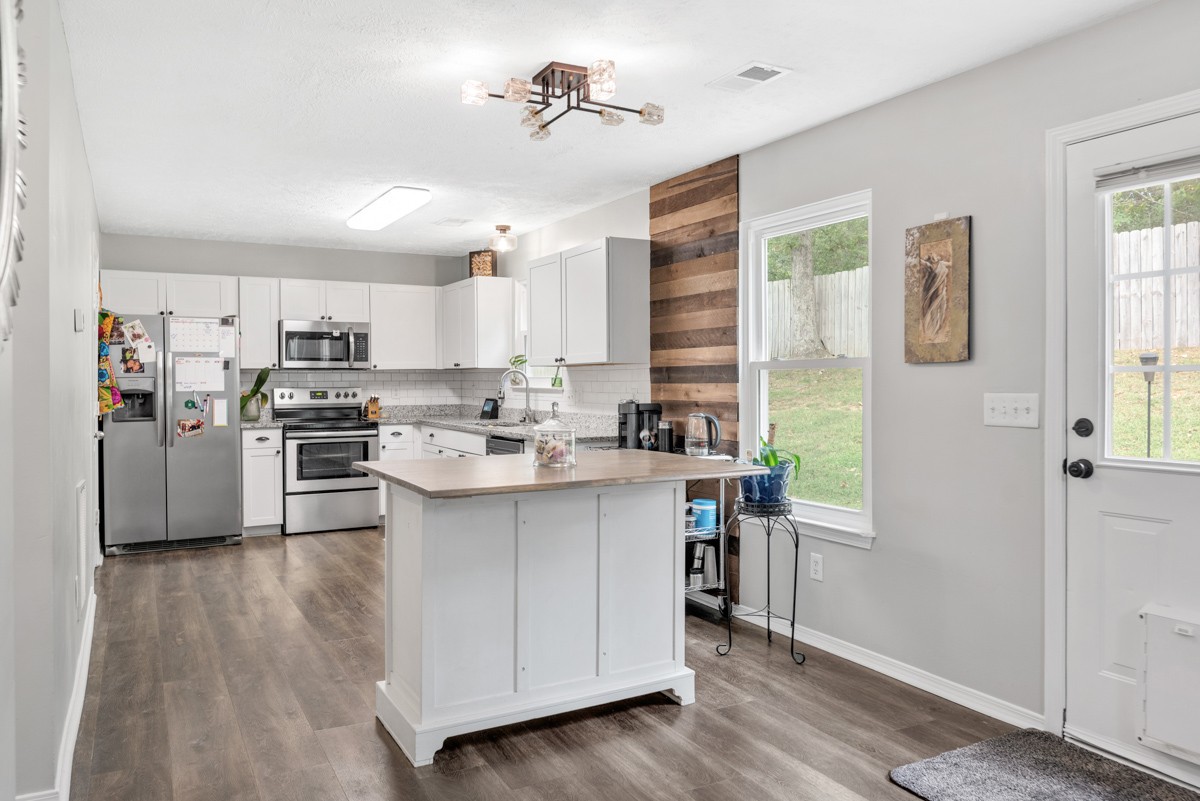 7226 Hidden Lake Drive Fairview, TN 37062 - Photo 13 of 54 a kitchen with stainless steel appliances a sink a stove a refrigerator cabinets and a window