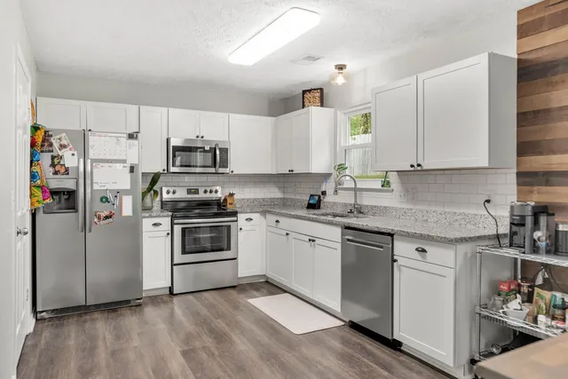 a kitchen with stainless steel appliances granite countertop a stove a sink and a refrigerator