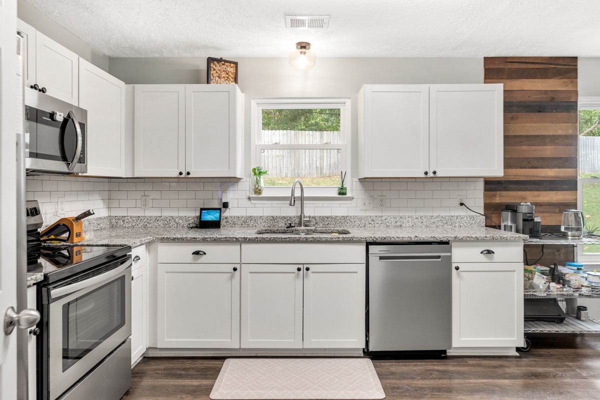 7226 Hidden Lake Drive Fairview, TN 37062 - Photo 16 of 54 a kitchen with granite countertop white cabinets and white appliances