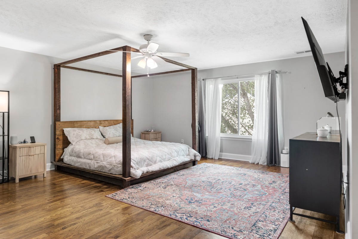 7226 Hidden Lake Drive Fairview, TN 37062 - Photo 21 of 54 a bedroom with a bed and wooden floor