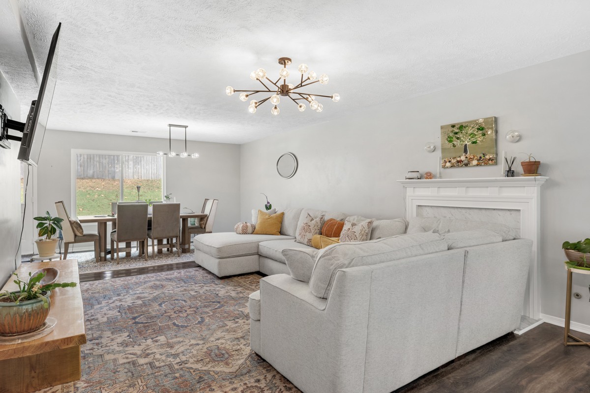 7226 Hidden Lake Drive Fairview, TN 37062 - Photo 10 of 54 a living room with furniture a chandelier and a painting on the wall