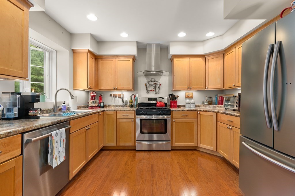 4 Mentas Circle Woburn, MA 01801 - Photo 30 of 41 a kitchen with stainless steel appliances granite countertop a refrigerator a sink dishwasher a stove and white cabinets with wooden floor