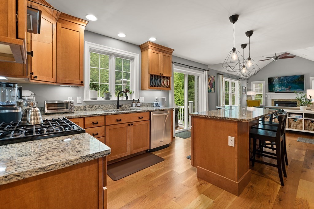 4 Mentas Circle Woburn, MA 01801 - Photo 4 of 41 a kitchen with stainless steel appliances granite countertop a stove top oven a sink dishwasher a dining table and chairs with wooden floor