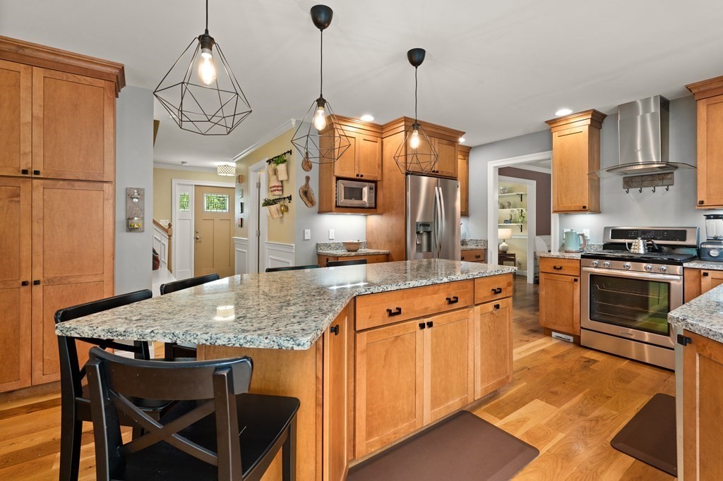 4 Mentas Circle Woburn, MA 01801 - Photo 6 of 41 a kitchen with stainless steel appliances granite countertop a stove a refrigerator a kitchen island a sink dishwasher and wooden cabinets with wooden floor