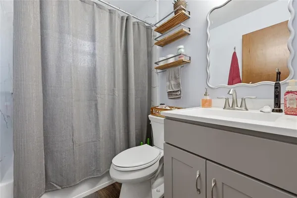 a bathroom with a sink a toilet and shower curtain