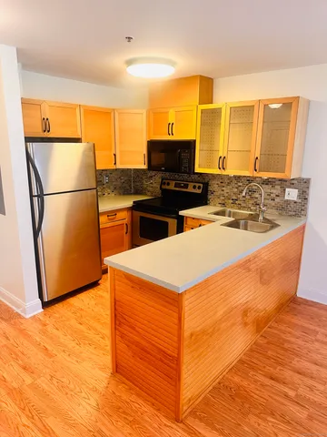 a kitchen with stainless steel appliances a refrigerator a stove top oven and a sink
