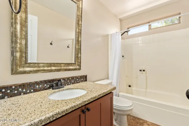 a bathroom with a granite countertop sink toilet and shower