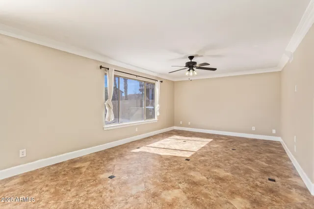 an empty room with windows and ceiling fan
