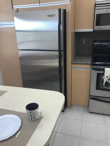 a kitchen with a refrigerator and a stove