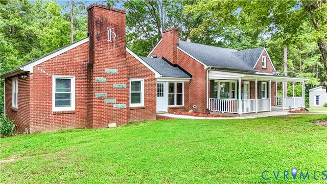 a view of a house with a yard and sitting area