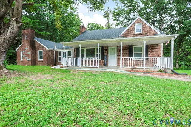 a front view of a house with a yard and green space