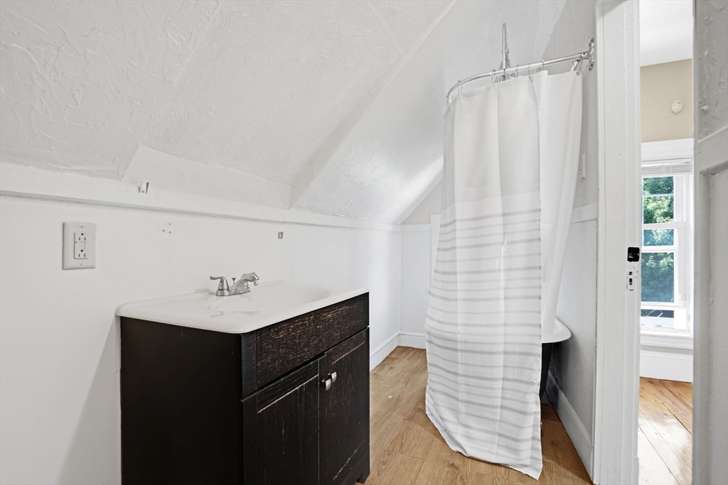 49 Elmore Street, Unit 3 Boston, MA 02119 - Photo 11 of 12 a bathroom with a sink a mirror and shower