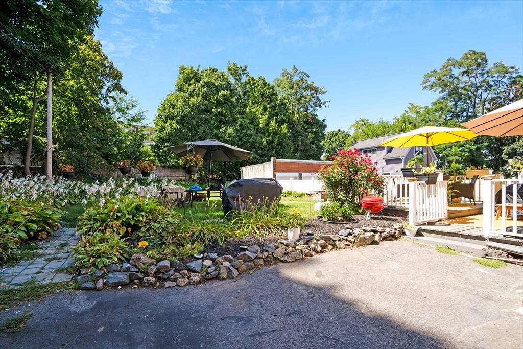 49 Elmore Street, Unit 3 Boston, MA 02119 - Photo 12 of 12 a view of a patio with table and chairs under an umbrella