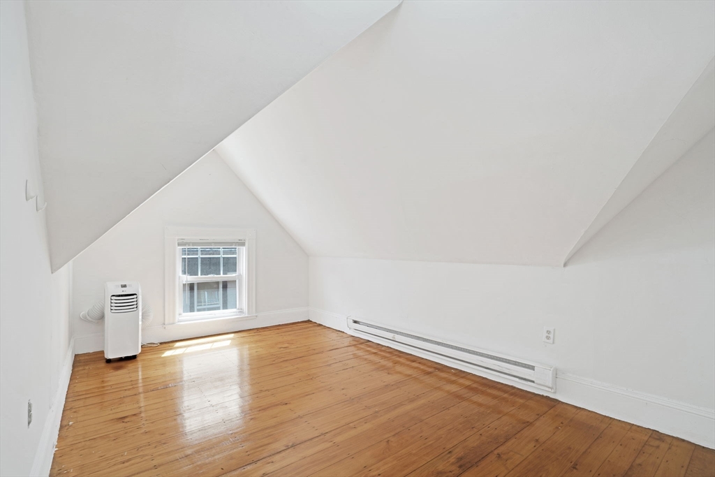 49 Elmore Street, Unit 3 Boston, MA 02119 - Photo 5 of 12 an empty room with wooden floor and windows