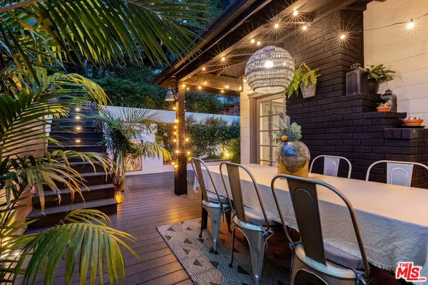 a view of a patio with table and chairs with wooden floor and fence