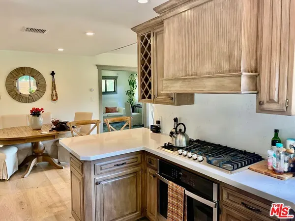 a kitchen with stainless steel appliances a sink cabinets and a large window