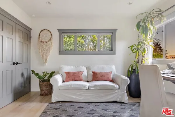 a living room with furniture a window and a flat screen tv