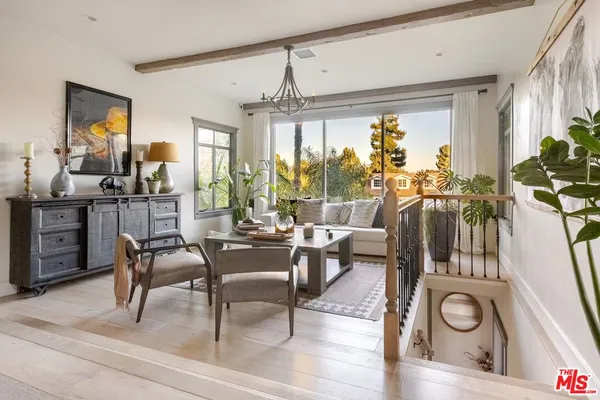 a living room with furniture a chandelier and a large window