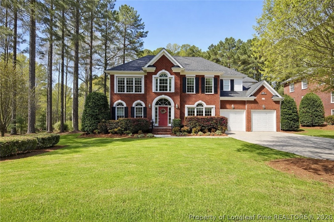 a front view of a house with yard and green space