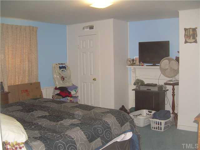 1424 Sykes Road Spring Hope, NC 27882 - Photo 7 of 9 a bedroom with a bed and wooden floor