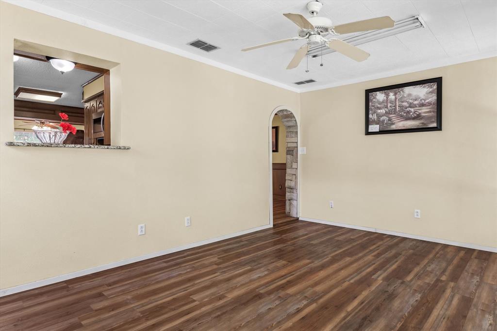 507 Cedar Street Edgewood, TX 75117 - Photo 13 of 26 a view of an empty room with wooden floor and a ceiling fan
