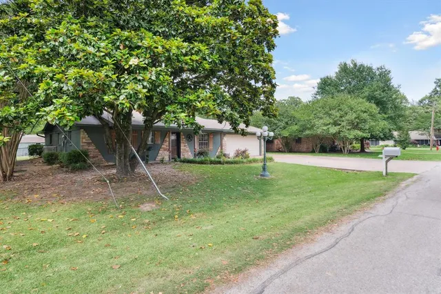 a bathroom with a granite countertop toilet a sink and a mirror