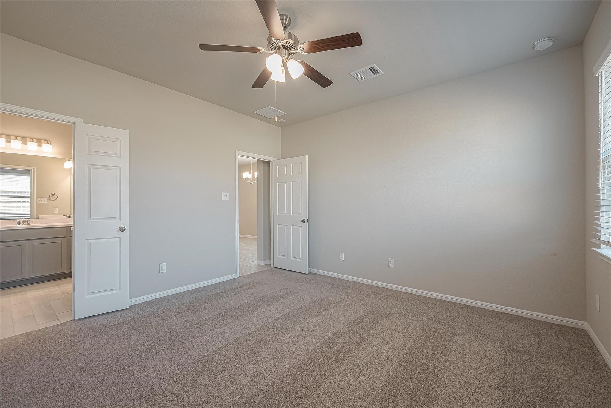 13306 Prado Rdg Lane Iowa Colony, TX 77583 - Photo 27 of 42 an empty room with chandelier fan and windows