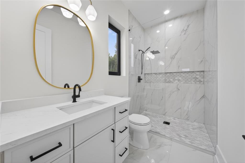 125 Rocky Rdg Way Auburn, GA 30011 - Photo 46 of 68 a bathroom with a sink a toilet and a mirror