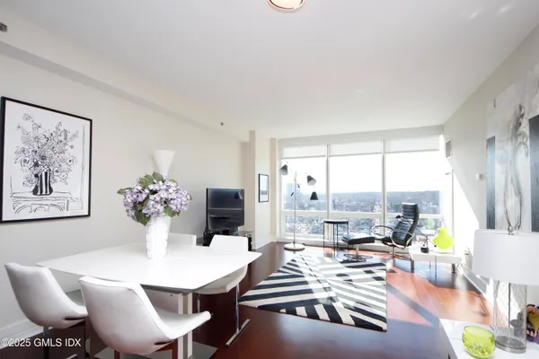 a view of a dining room with furniture a chandelier and wooden floor