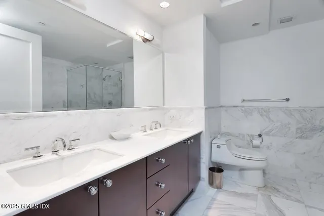 a bathroom with a double vanity sink mirror and toilet