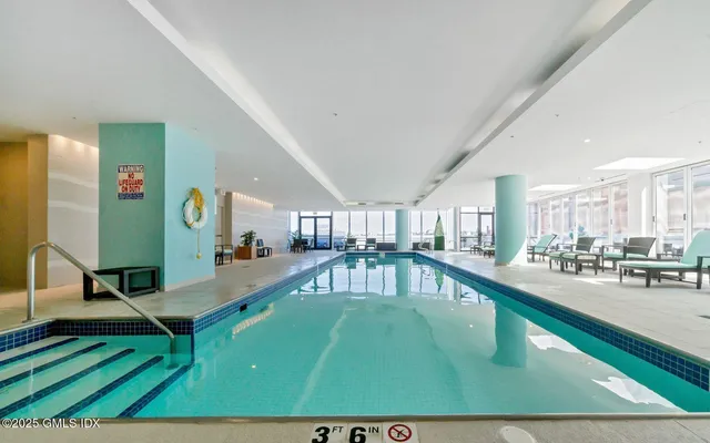 a living room with kitchen view and pool table