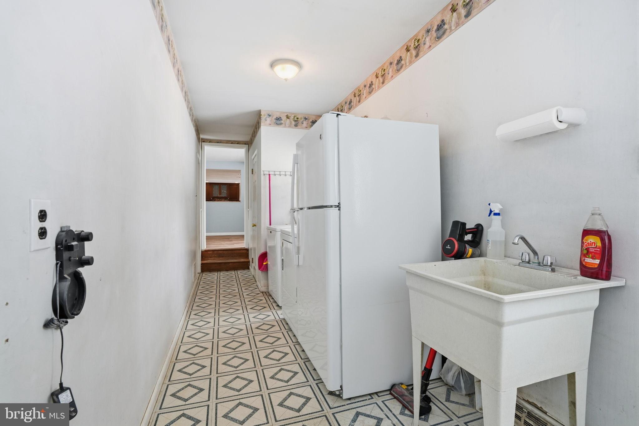 32 Lower Hilltop Road Yardley, PA 19067 - Photo 25 of 37 a hallway with a white stove a refrigerator and a table