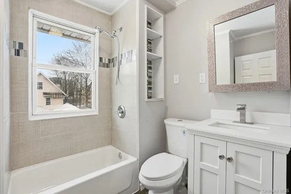 a bathroom with a granite countertop toilet a sink and a bathtub