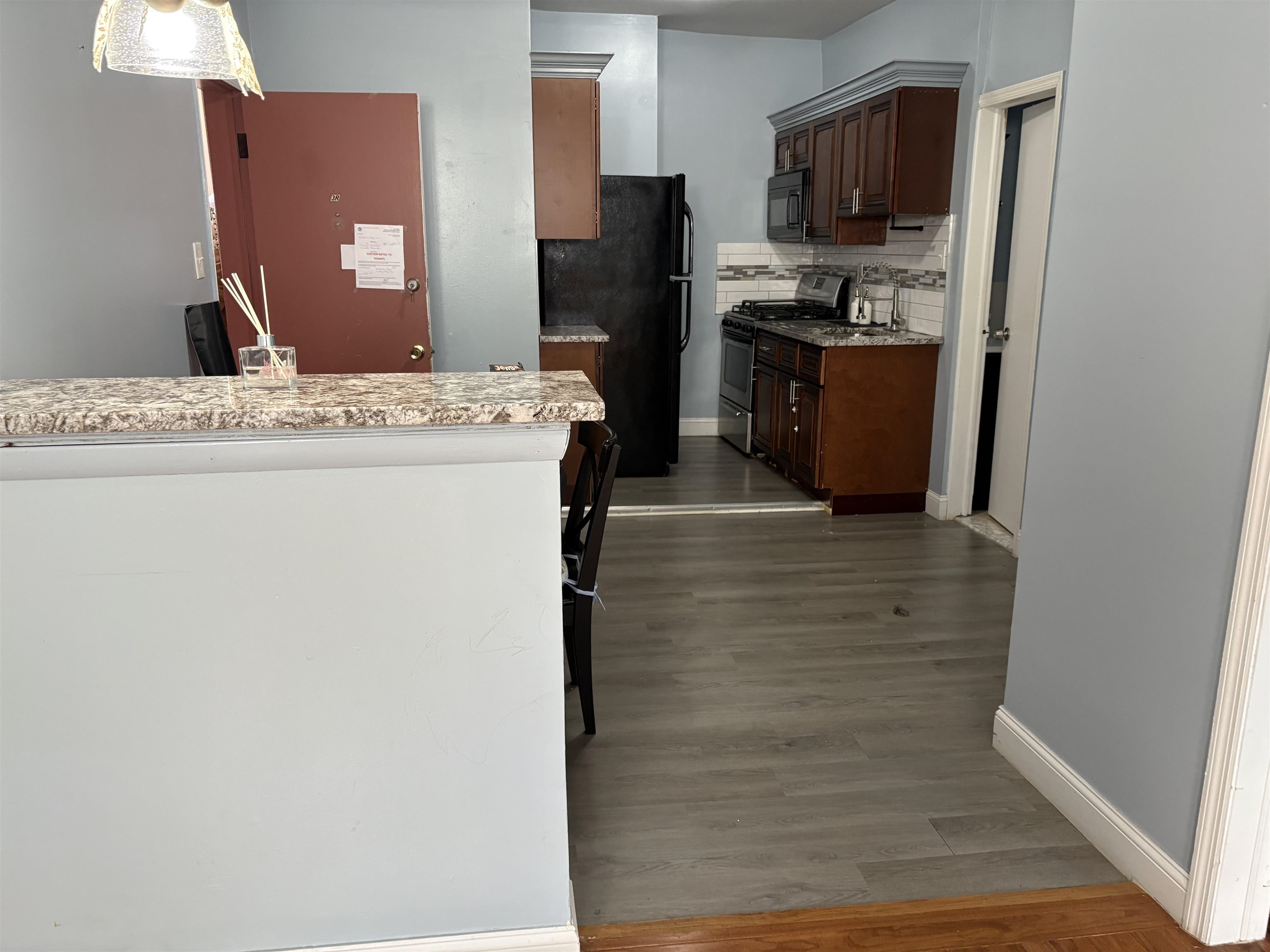 33 Emerson Avenue, Unit 5 Jersey City, NJ 07306 - Photo 5 of 8 a hall with kitchen island a stove a refrigerator and a cabinets
