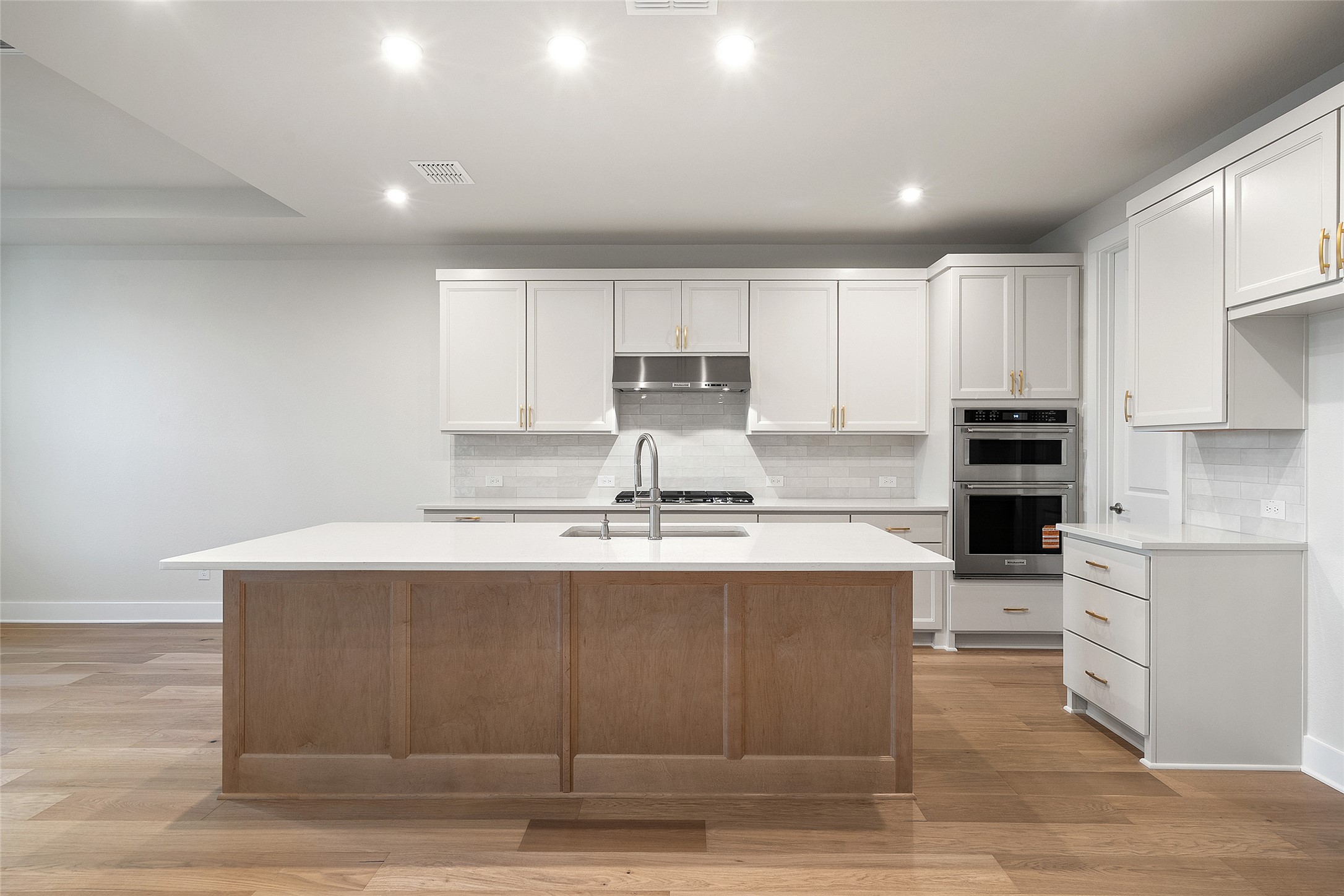 5336 Cosenza Trace Leander, TX 78641 - Photo 13 of 40 Kitchen featuring white cabinets, recessed lighting, stainless steel appliances, a center island with sink, and light wood-type flooring